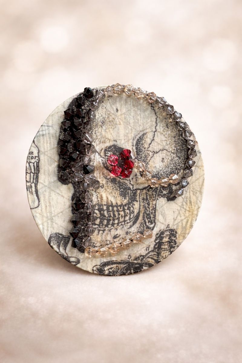 A beaded embroidery project of a skull with red beads