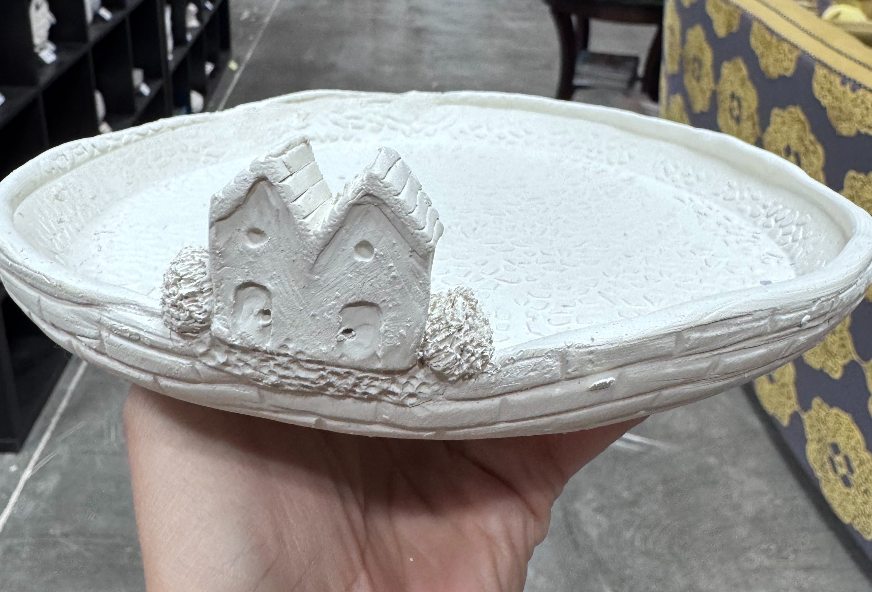 A clay project of a tray with two small houses on the edge