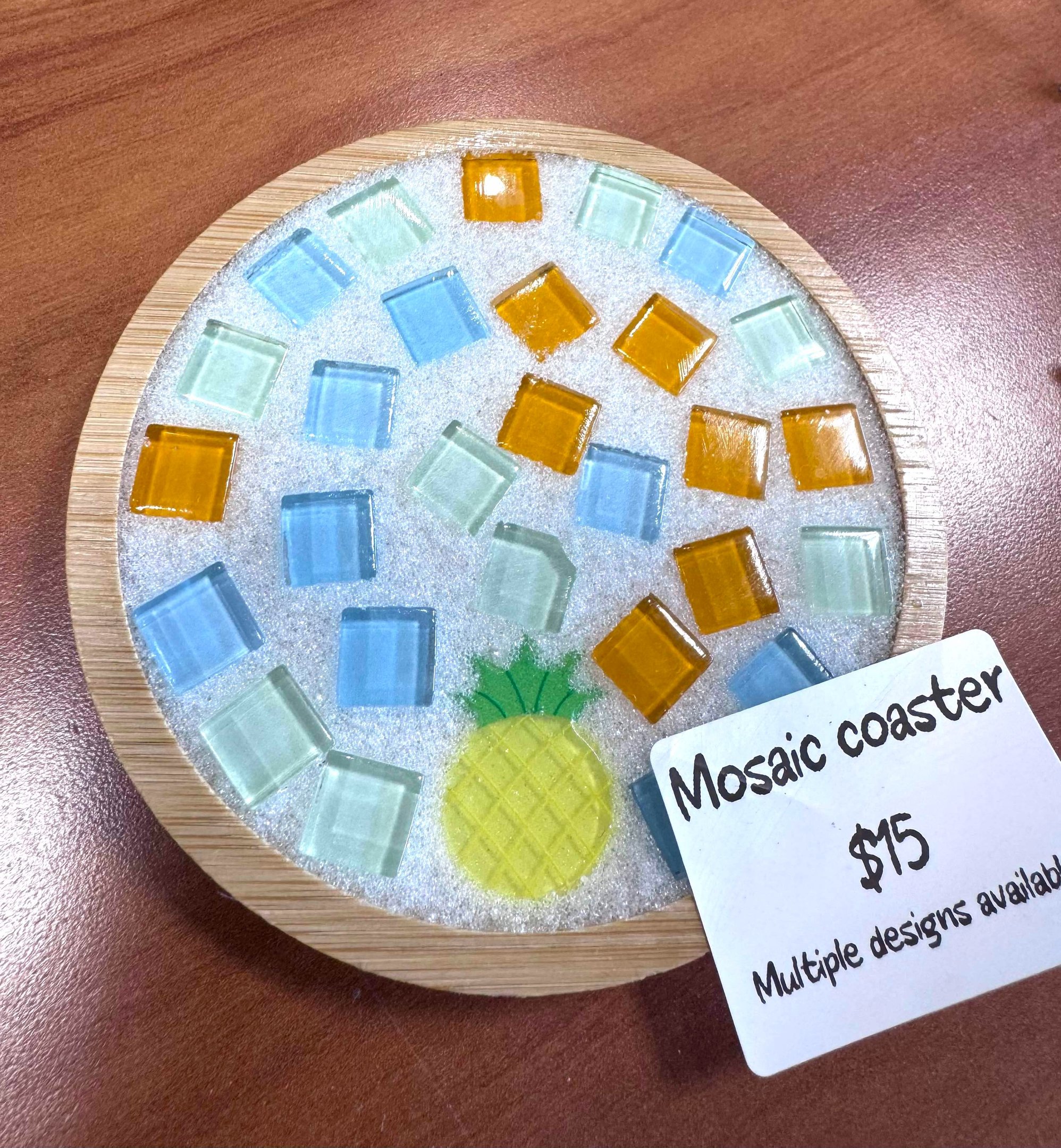 A mosaic coaster with colorful tiles and crystal grout