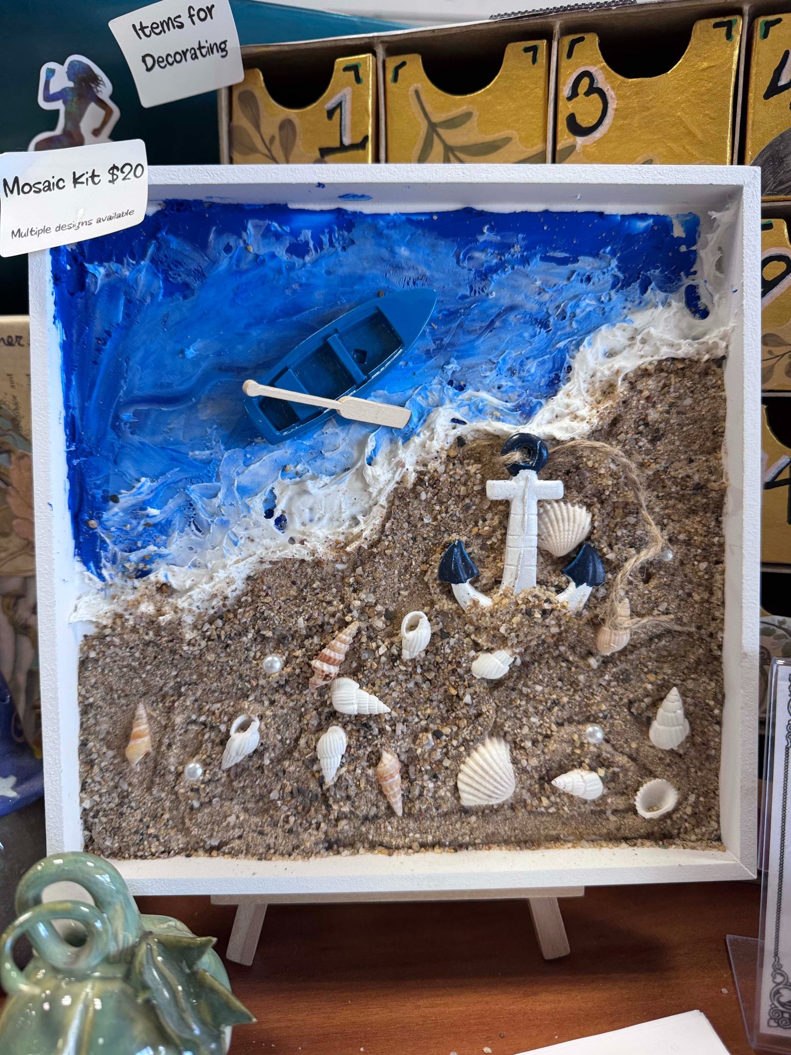 A shadow box with a 3D beach scene including realistic water and sand